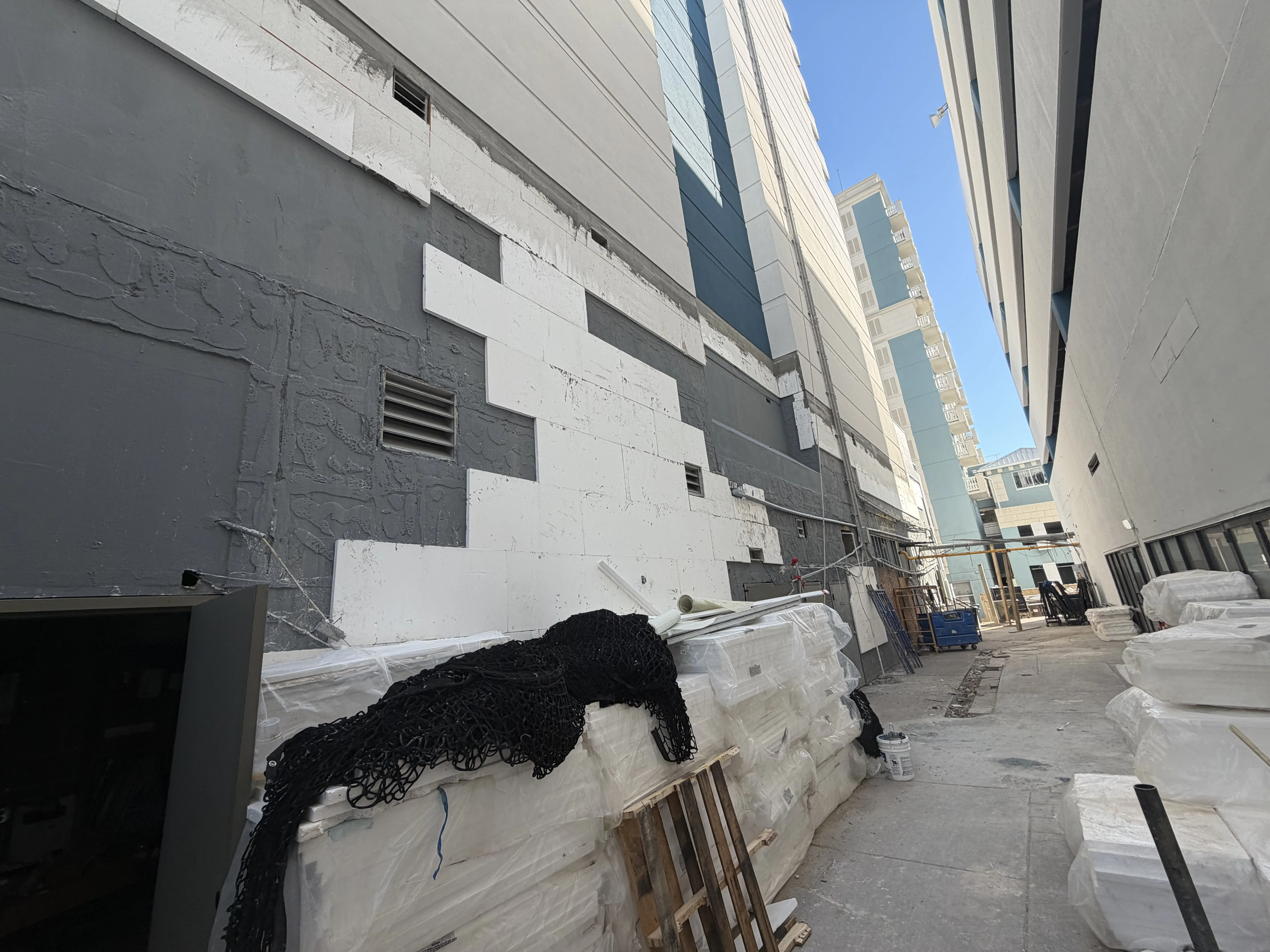 Materials and exterior restoration work along a commercial hotel