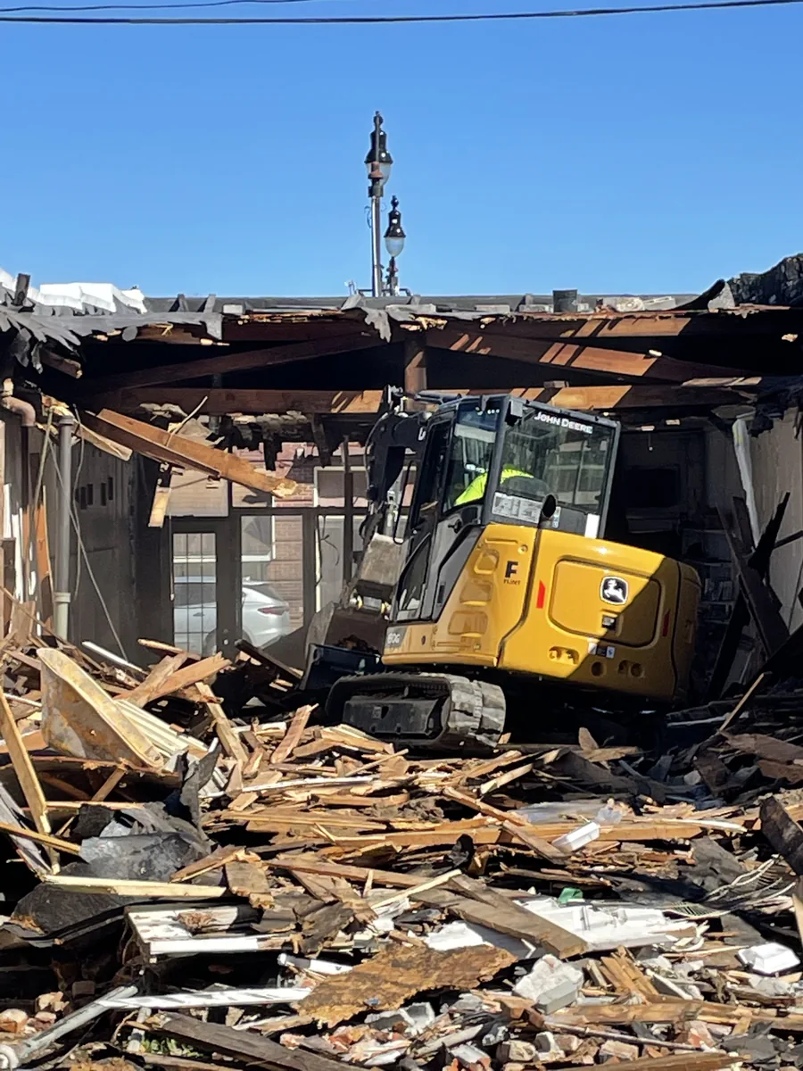Compact excavator performing selective demolition