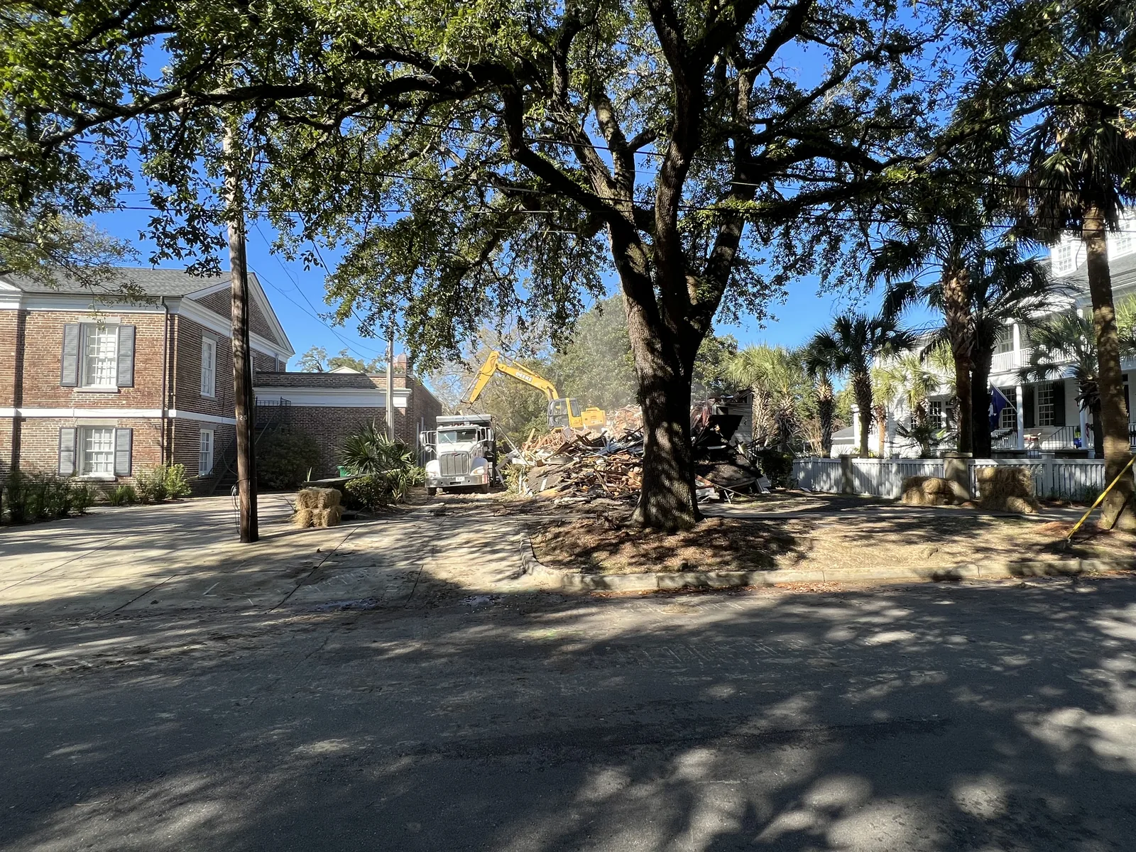 Residential demolition beside a mature oak tree