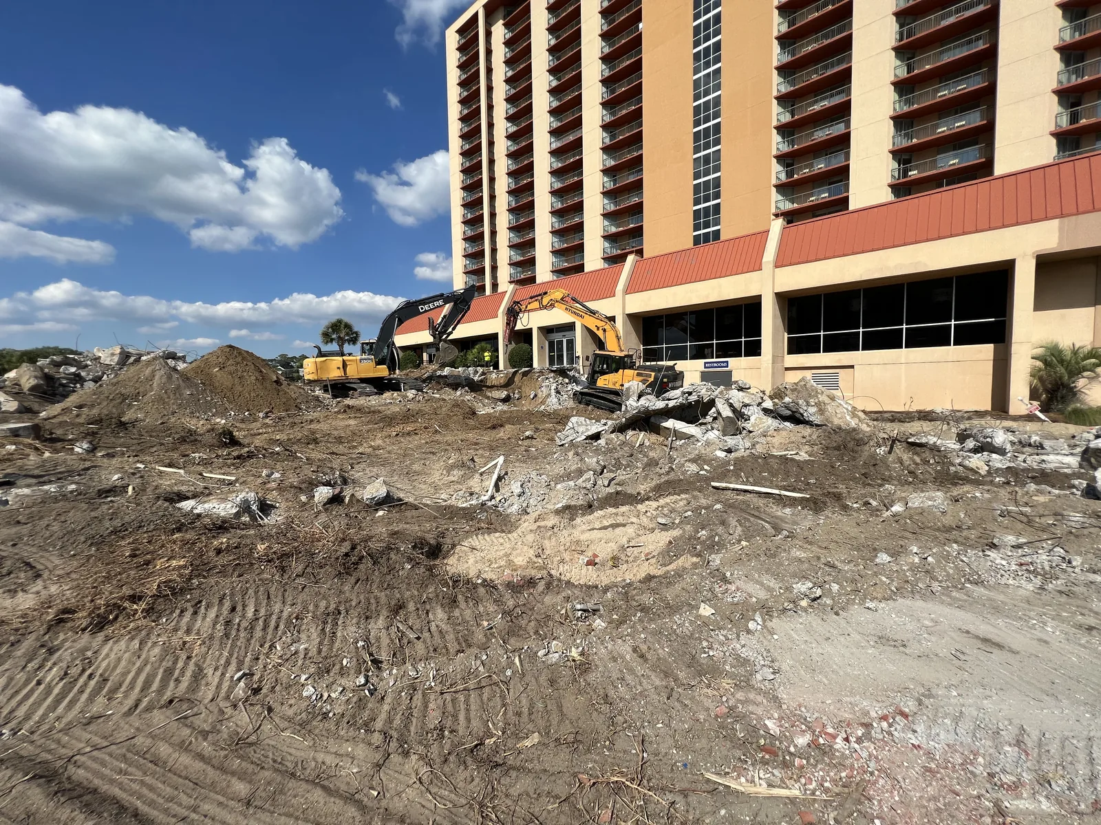 Excavator removing hotel foundations and concrete