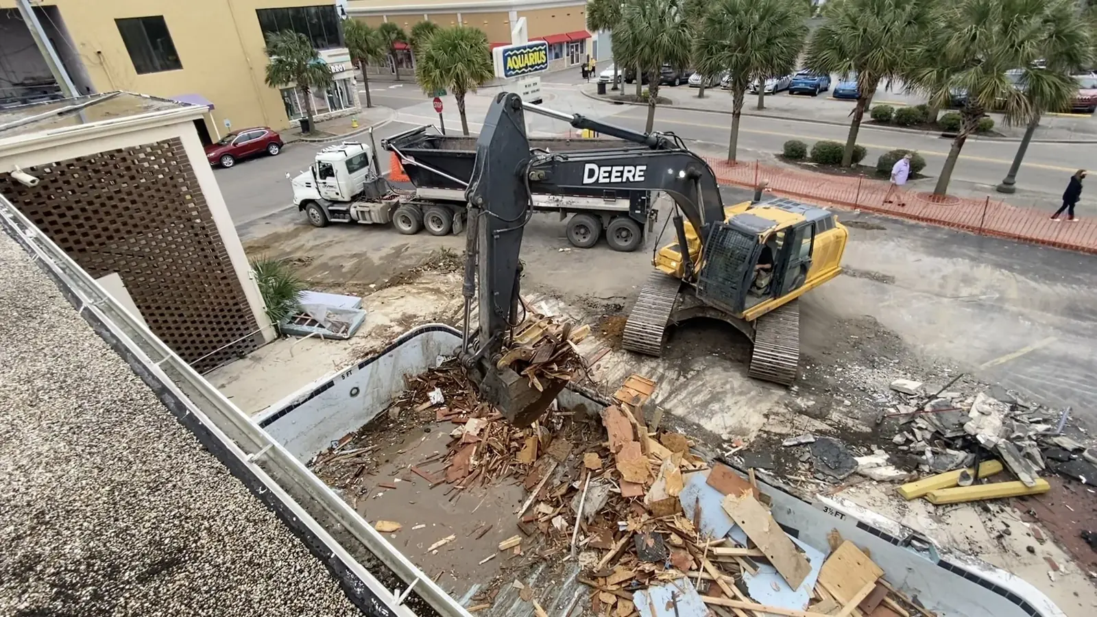 John Deere excavator removing a swimming pool during demolition