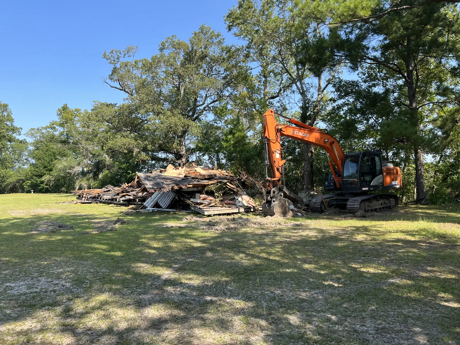 Excavator loading debris during residential demolition