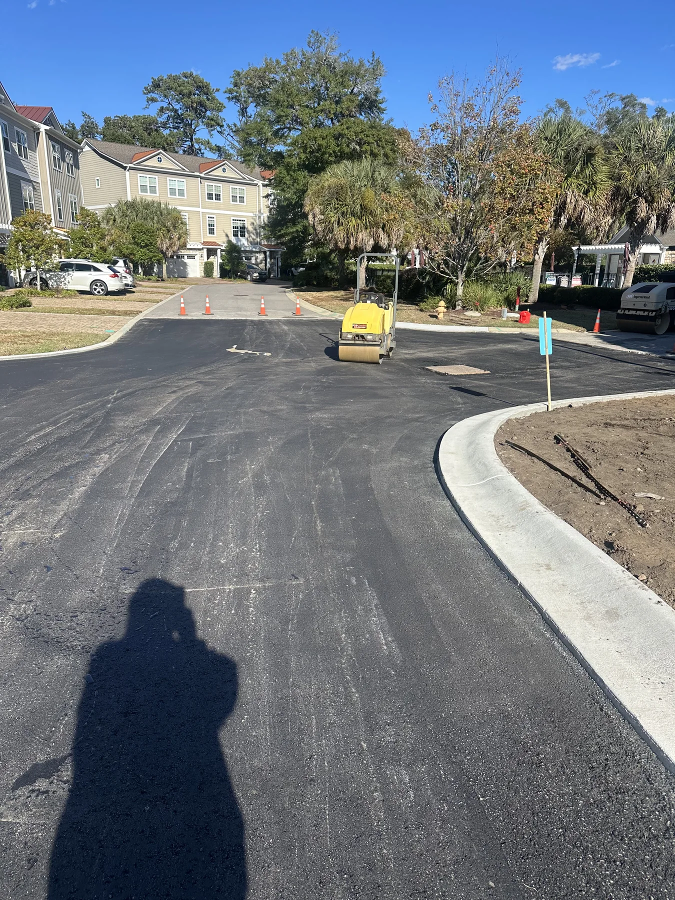 Fresh asphalt paving with a roller compacting the new surface