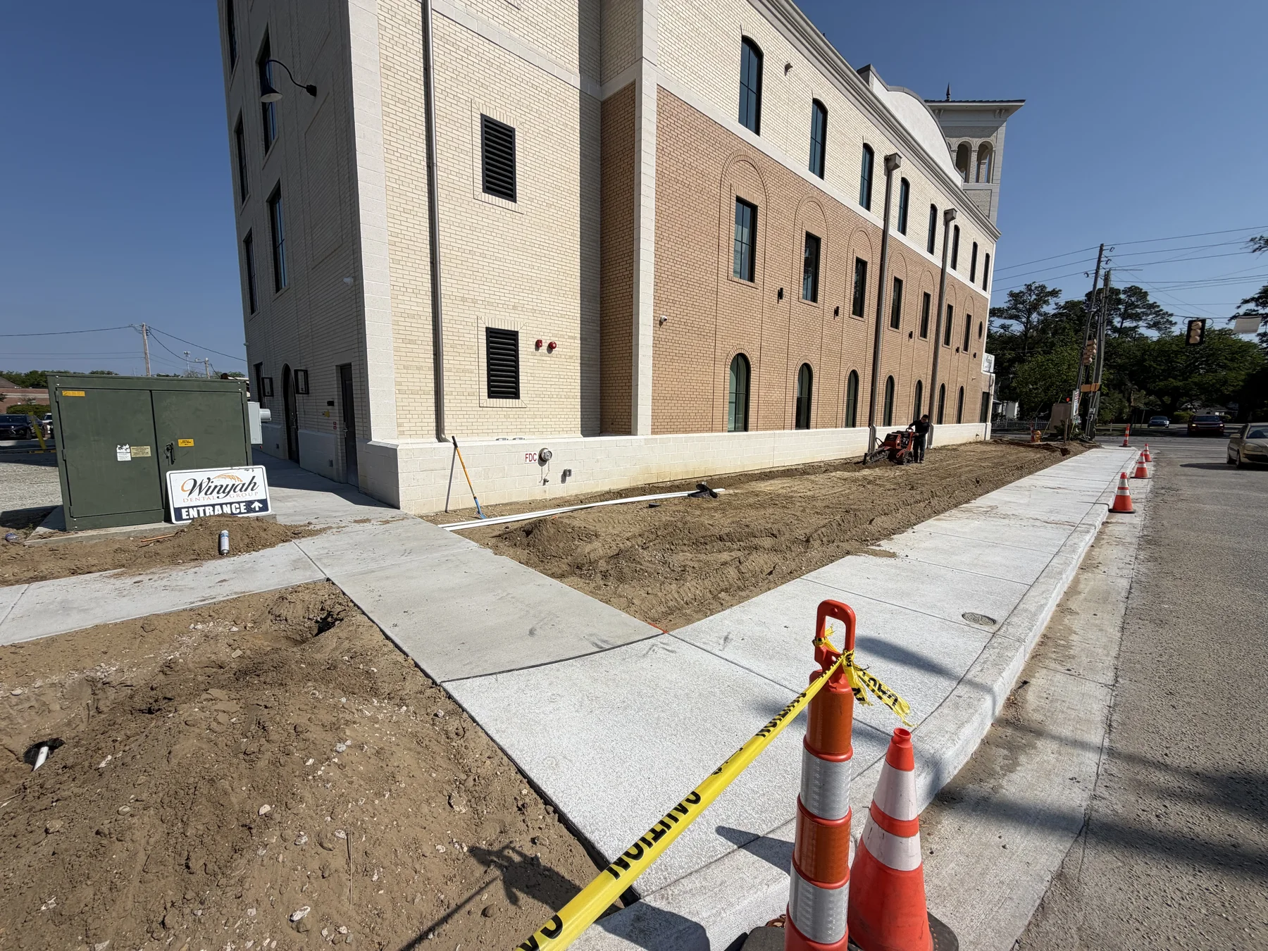 New concrete sidewalk installed beside a commercial building